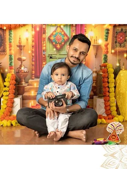 A future photographer in the making. A father and son pose together during our Diwali shoot, with the little one holding a camera.