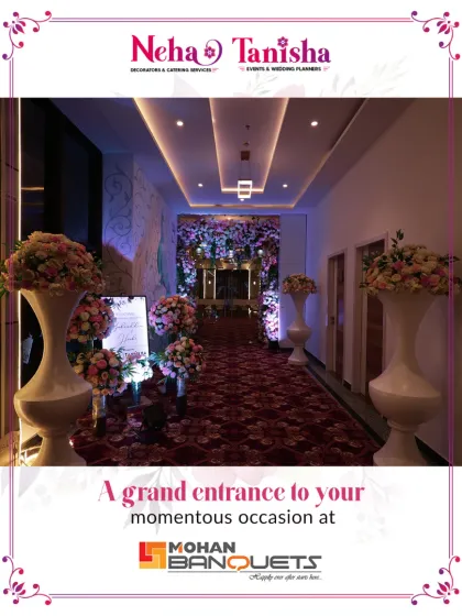 A grand entrance for your momentous occasion. Guests are welcomed through a beautifully decorated hallway with a plush red carpet, floral arrangements, and elegant vases, leading to the main event hall.