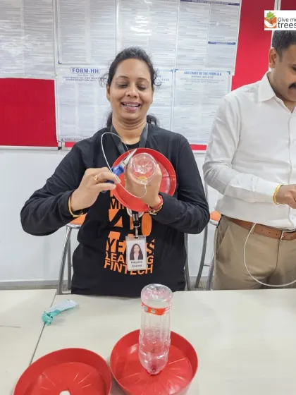 A participant at our Fiserv Gurgaon workshop smiles as she assembles a bird feeder from a plastic bottle. This is upcycling in action.