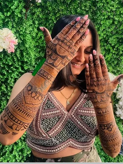 A playful pose from a bride, delighted with the deep color of her mehndi.