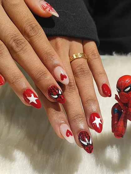 A detailed shot of the Spiderman nails, focusing on the hand-painted character face and heart accents.