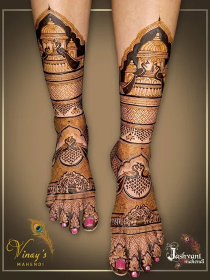 Full leg bridal mehndi with intricate palace and peacock motifs. The design extends from the toes to just below the knee, creating a stunning visual impact.