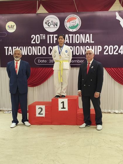 A student stands tall on the podium, a testament to her hard work and the quality of our competitive coaching.