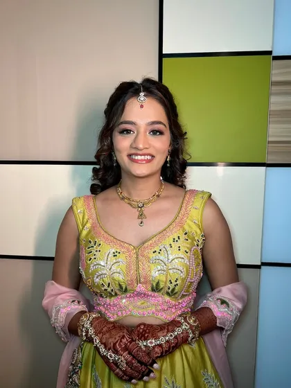 A smiling portrait of the client, looking radiant for her mehendi.