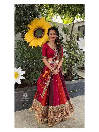 Prathima posing next to a giant sunflower at her haldi ceremony. Her happy, vibrant look perfectly matches the fun and colorful theme of the event.
