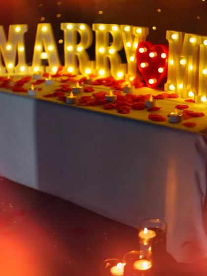 It's all in the details. Our popular 'MARRY ME' marquee lights, surrounded by scattered rose petals and tea-light candles, create an instantly romantic and photo-ready scene.