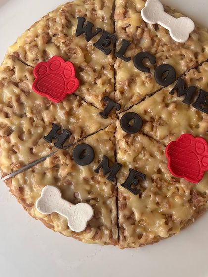 Welcome home with a dog-friendly pizza! This fun cake is made with a savory base and decorated to look like a real pizza, perfect for a homecoming celebration.