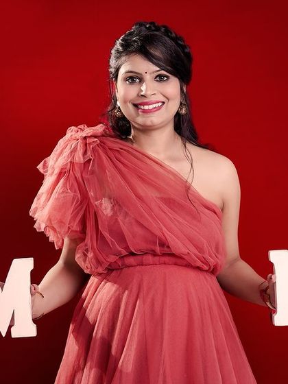 A fun and celebratory studio shot of a mother-to-be holding "MOM" letters. We use creative props to add a personal and joyful touch to your maternity portraits.