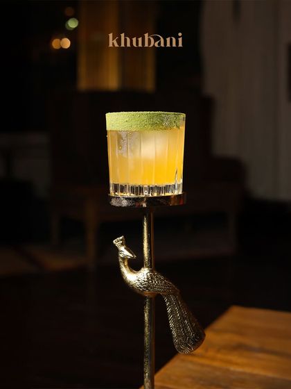 Here’s to the moments that deserve a toast. This elegant cocktail is served in a unique peacock-stand glass, embodying our commitment to artistry in every detail.