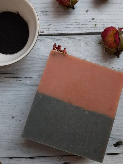 A simple, elegant bar of Charcoal Rose soap. The two-tone layer design shows the combination of French pink clay for gentle cleansing and activated charcoal for a deeper clean.