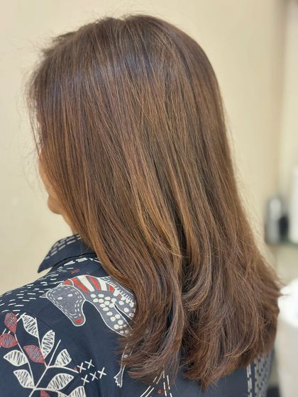 A side view of a layered haircut enhanced by a glossy, single-tone color. This shows how a great global color can make a simple cut look incredibly polished and healthy.