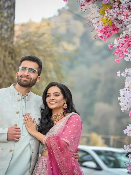 The couple posing against a beautiful floral arch, looking out towards their future together.