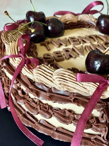 A close-up of the piping detail on our Chocolate & Cherry Cake. This one was for a special 27th birthday, playfully reading "Twenty Serving".