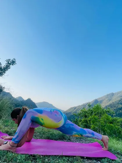 A deep stretch in Lizard Pose (Utthan Pristhasana) against a stunning mountain backdrop. This pose is excellent for opening the hips and groin.