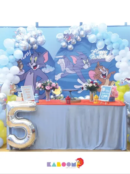 A classic Tom and Jerry theme brings cartoon chaos and fun to this fifth birthday party, with blue and silver balloons and large character backdrops.