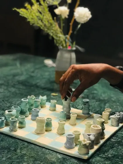 Yes, you can even make your own chess set. We call this one 'Cocoa Clash,' a charming, hand-glazed set crafted right here in our studio. It’s a reminder that art can be playful.