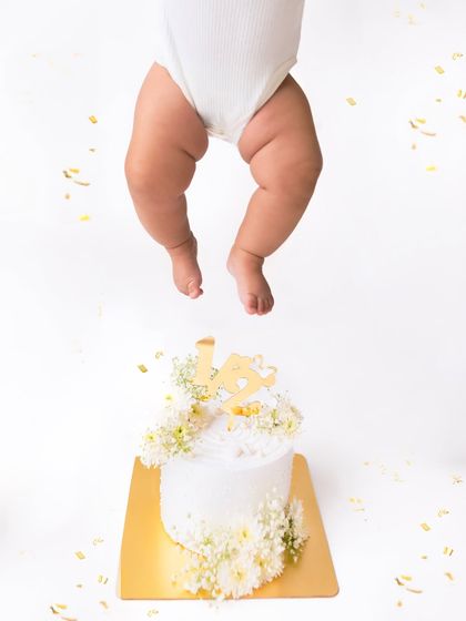 Just the little legs. This creative and funny shot from a half-birthday cake smash session is a playful way to remember this milestone.