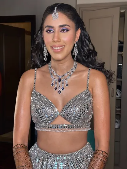My beautiful client looking stunning for her sangeet in a silver lehenga. I created a purple eye makeup look to complement the cool tones of her outfit.