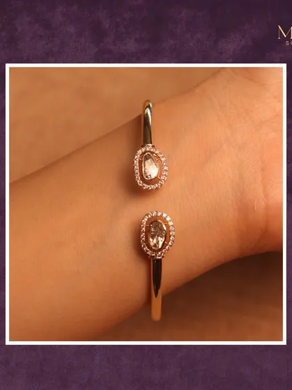 Subtle sophistication at its finest. This open gold bracelet with two diamond halos is a statement of modern grace, perfect for any look.