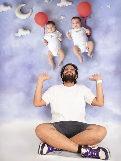 Let's have some fun! This creative composite shot shows daddy juggling his twin boys, who seem to be floating on balloons. It's a playful and unique way to create a memorable newborn portrait.