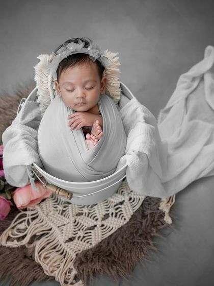 A vision in grey. This photo shows how a simple, neutral-colored swaddle and a rustic bucket can create a timeless and elegant portrait.