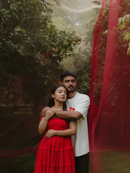 A quiet embrace amidst the trees. This soulful portrait of Deyana and Daral, with the soft red fabric creating a dreamy backdrop, speaks of comfort and togetherness.