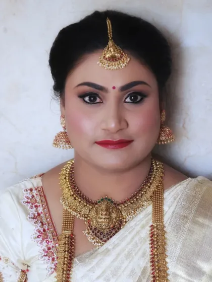 A beautiful portrait of a bride ready for her muhurtham. Her makeup is classic and elegant, with defined eyes and a bold lip, designed to look stunning with her traditional attire and heavy gold jewellery.