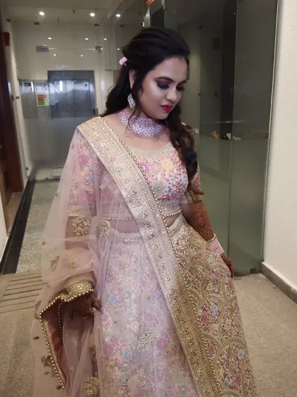 A beautiful client in a pastel pink floral lehenga, perfect for a daytime engagement or sangeet.