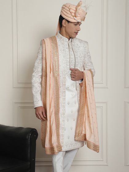 A full-length shot of the ivory sherwani with a peach stole, showcasing the complete, coordinated look. The outfit is a perfect example of our made-to-measure promise, ensuring a flawless fit.