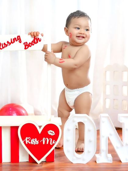 Taking charge of the kissing booth. This dynamic photo captures the playful energy of a one-year-old on the move during his birthday session.