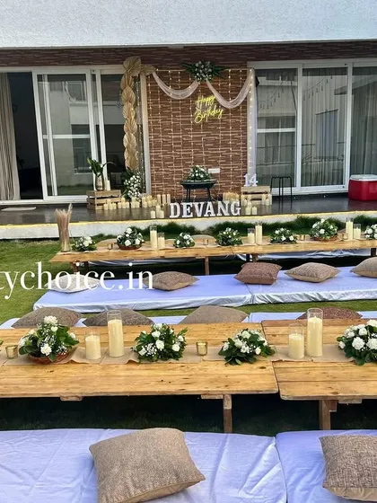 A full view of the beautiful and rustic low-seating dining setup for an intimate outdoor birthday party.