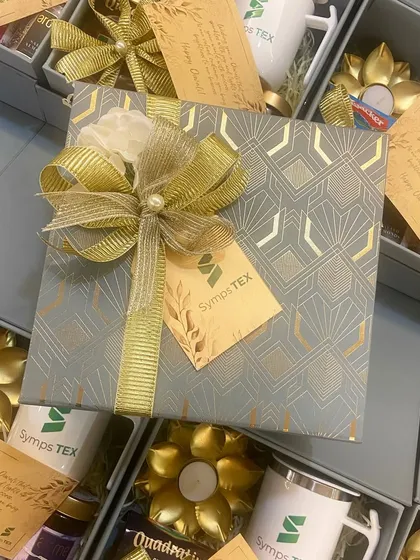 Our absolute bestseller for corporate Diwali gifting. This elegant grey box for Symps TEX includes a customized mug, gourmet treats, and a lotus tea light holder.