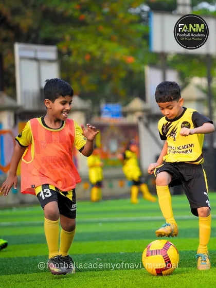 Two young players battling for possession, learning the importance of tenacity and fair play.