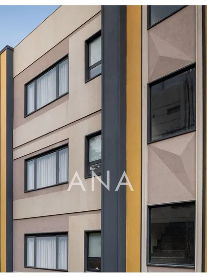 A detailed view of the Yellow Line Apartment's facade, showing the geometric patterns and the vertical yellow band. This was a solution to add visual interest and break the monotony of a flat surface on a narrow plot.