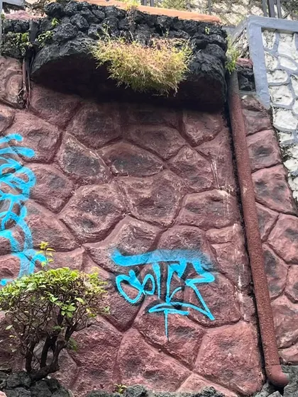 A quick tag on a textured rock wall during a rap cypher event. Art and music, it's all part of the same hip-hop culture.