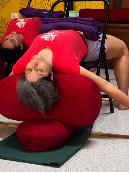 Part of a de-stress sequence: A deep, supported backbend over a chair and bolsters. This level of support encourages complete relaxation and release, which is essential for managing chronic stress.
