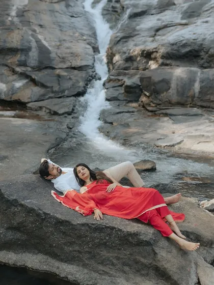 Finding stillness together. This serene pre-wedding portrait by a cascading waterfall captures a moment of pure peace and connection, away from the chaos of wedding planning.