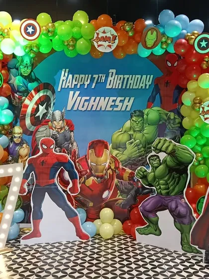Even on a budget, I can assemble an epic party. This action-packed Avengers theme, set up in a cafe, features vibrant character cutouts and a dynamic balloon arch, proving a heroic celebration doesn't need a blockbuster budget.