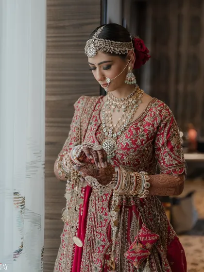 A timeless bridal portrait capturing the intricate details of the lehenga, the stunning jewelry, and the quiet anticipation of the bride on her wedding day.