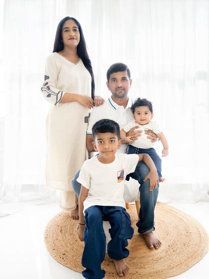 A classic family portrait with everyone looking at the camera. The coordinated white and denim outfits create a clean and cohesive look.