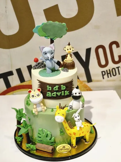 This 5kg two-tiered jungle-themed cake showcases our detailed fondant work. It's covered in adorable, hand-sculpted 3D animals like a giraffe, elephant, and tiger, creating a playful safari scene that kids will love.