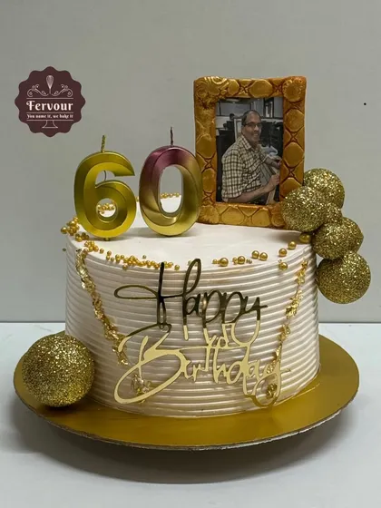 A 60th birthday cake with a personal touch. This chocolate truffle cake features an edible photo in a golden frame, along with glittery gold balls and a custom topper.