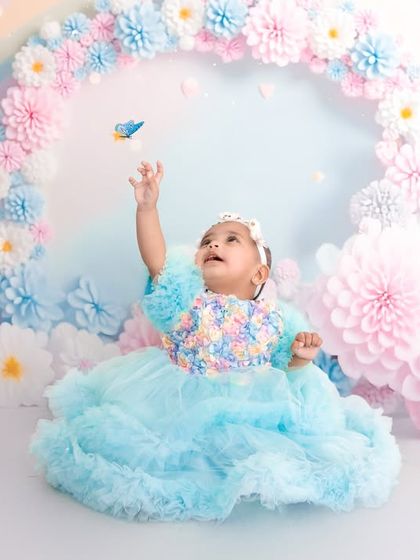 A magical moment captured as the baby reaches for a tiny blue bird prop. These interactive elements make the session more engaging and result in beautiful, candid photos.