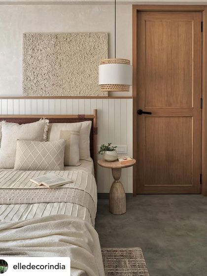 Featured in Elle Decor, this bedroom from the Zen House showcases a serene design with vertical fluting, a textured art piece, and a warm wooden bed, creating a rustic and airy feel.