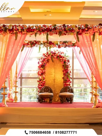 A traditional mandap setup for an indoor wedding. The floral arch, elephant-themed chairs, and brass lamps create a classic and auspicious ambiance.