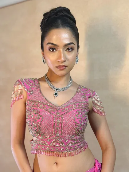 The model looking fierce and beautiful with her high bun and stunning pink lehenga.