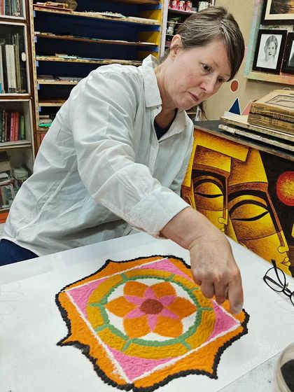 An international student learning the traditional art of rangoli. Art transcends language and cultural barriers, connecting us all.