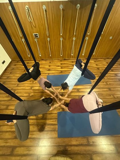 An overhead view of our students in a group aerial pose, showing the beautiful symmetry and connection we create in class.