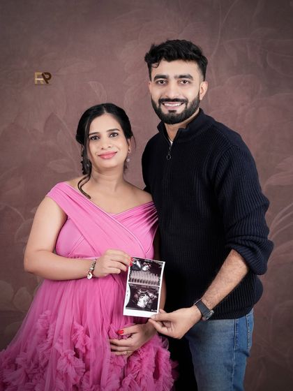 A portrait that captures the joy and hope of pregnancy. The mom-to-be holds her ultrasound picture while wearing a lovely pink gown, blending the medical milestone with artistic photography.