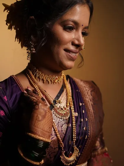 A close-up portrait of the bride, showing off her intricate mehndi and the soft glam of her engagement makeup.